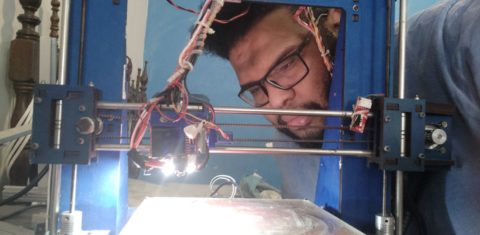 Lucas confere sua impressora 3D feita de sucata eletrônica: máscaras face-shield para unidades da saúde da área Alemão (Foto: Divulgação)