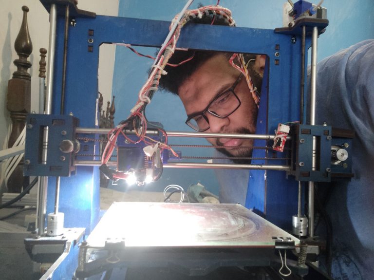 Lucas confere sua impressora 3D feita de sucata eletrônica: máscaras face-shield para unidades da saúde da área Alemão (Foto: Divulgação)