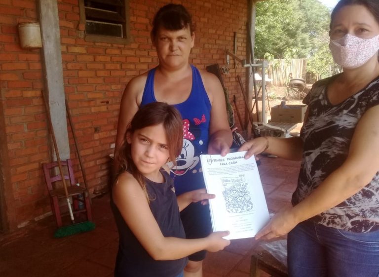 A professora Simone Stefanello entrega apostila com atividades escolares para aluna na zona rural de Bossoroca, no oeste gaúcho: dificuldade de acesso à internet e distribuição de material com o próprio carro (Foto: Zelir Oliva Nimett dos Santos)