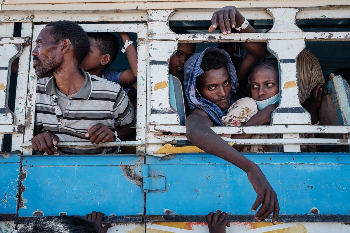 Refugiados etíopes são transferidos de ônibus após cruzarem a fronteira em Hamdayit, leste do Sudão. Foto Yasuyoshi Chiba/AFP. Dezembro de 2020