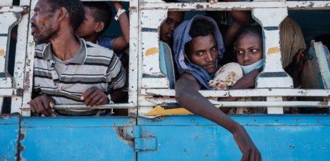 Refugiados etíopes são transferidos de ônibus após cruzarem a fronteira em Hamdayit, leste do Sudão. Foto Yasuyoshi Chiba/AFP. Dezembro de 2020