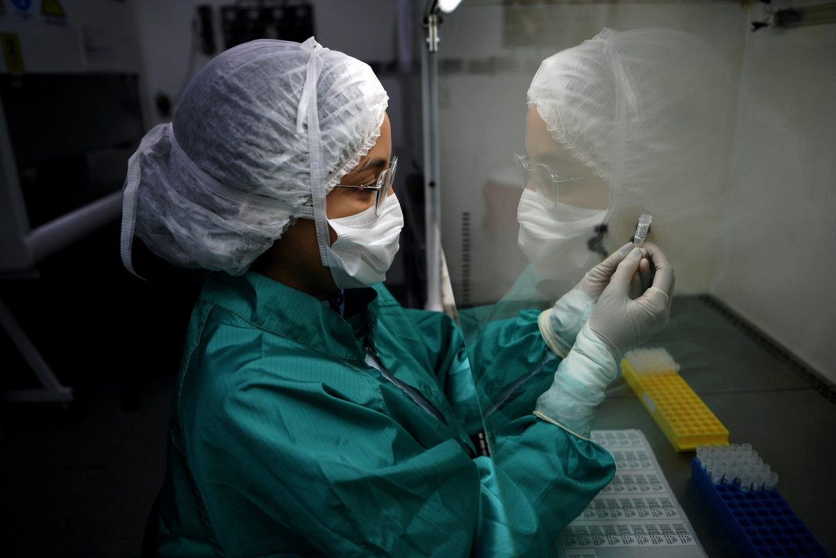 Técnico de Bio-Manguinhos trabalha nos testes da covid-19. A instituição vai produzir mais de 200 milhões de doses de vacina contra a doença em 2021. Foto Carl de Souza/AFP