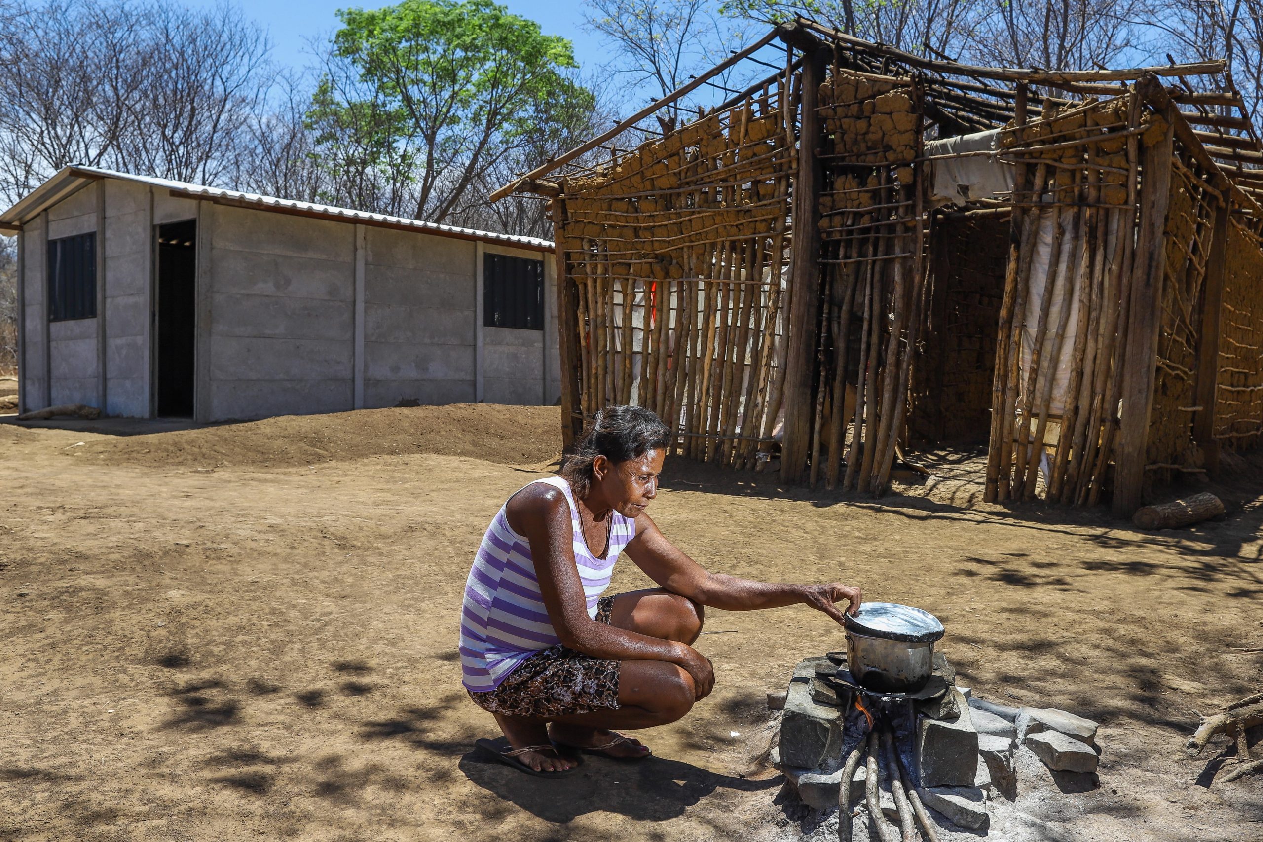A indígena Laurinha Gomes com seu fogão de lenha fora de casa: "não tem nada para comer aqui, só esse arroz mesmo" (Foto: Flávio Tavares)