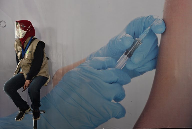 No estádio Istora Senayan, em Jacarta, na Indonésia, uma mulher espera a sua vez para ser vacinada contra a covid-19. Foto Adek Berry/AFP