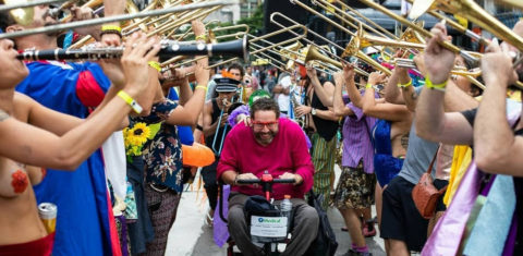 Cadeirante em desfile da Orquestra Voadora no carnaval de rua do Rio de Janeiro