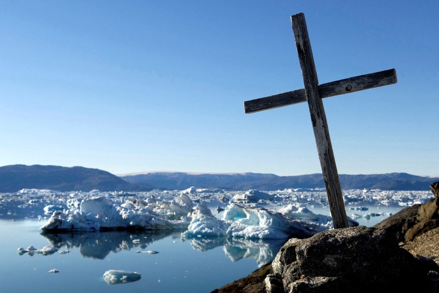 Cruz à beira do Oceano Ártico, no leste da Groenlândia: perda de toneladas de gelo provoca aumento do nível dos mares (Foto: Philippe Roy / Aureimage / AFP - 05/07/2020)