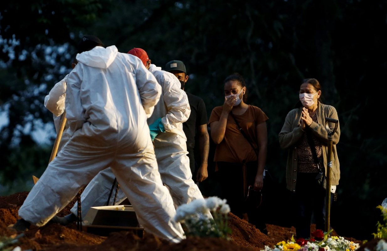 Parentes acompanham sepultamento de vítima da covid-19 em São Paulo: sem o censo, Brasil sabe cada vez menos sobre os brasileiros vivos, enquanto conta o número de mortos (Foto: Miguel Schincariol/AFP - 17/04/2021)