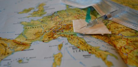 Turismo de vacina: máscara e seringa em cima de um mapa da Europa