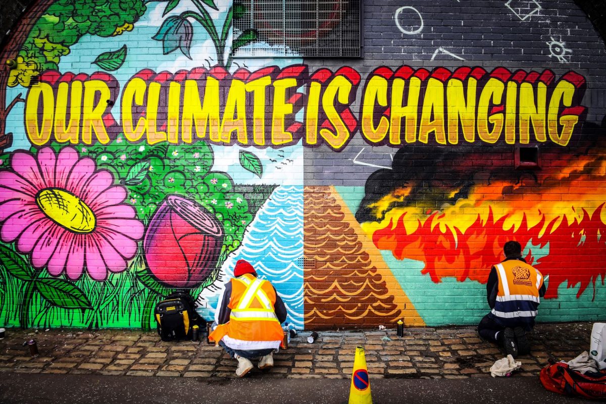 Artista pinta muro em Glasgow para chamar atenção sobre a emergência climático. (Foto: Andy Buchanan/ AFP)