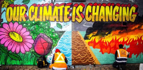Artista pinta muro em Glasgow para chamar atenção sobre a emergência climático. (Foto: Andy Buchanan/ AFP)