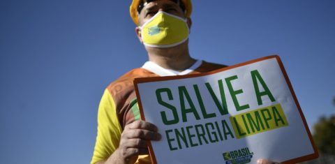 Manifestante segura um cartaz durante uma manifestação em Brasília como parte do movimento "Diga Sim à energia solar". Foto Mateus Bonomi/AGIF/AFP. Junho/2021