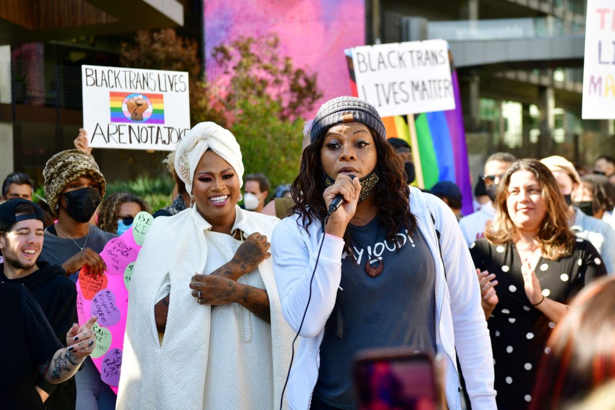 A jornalista Ashley Marie Preston, de branco, e a atriz Blossom C. Brown (ao microfone) - ambas mulheres trans - em protesto em frente à sede da Netflix: denúncia de transfobia contra comediante Dave Chappelle (Foto: Rodin Eckenroth / AFP - 20/10/2021)