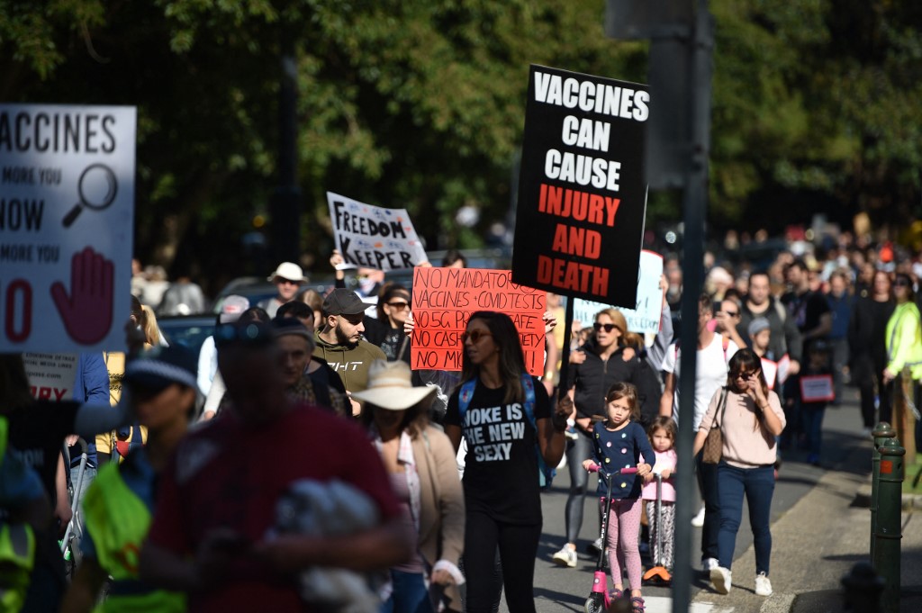 Manifestantes com cartazes contra a vacinação em protesto pelo fim de medidas restritivas impostas pela pandemia: grupos cristão usam mensagem 'Sangue de Jesus é minha vacina" contra a ciência (Foto: Peter Parks / AFP - 30/05/2021)