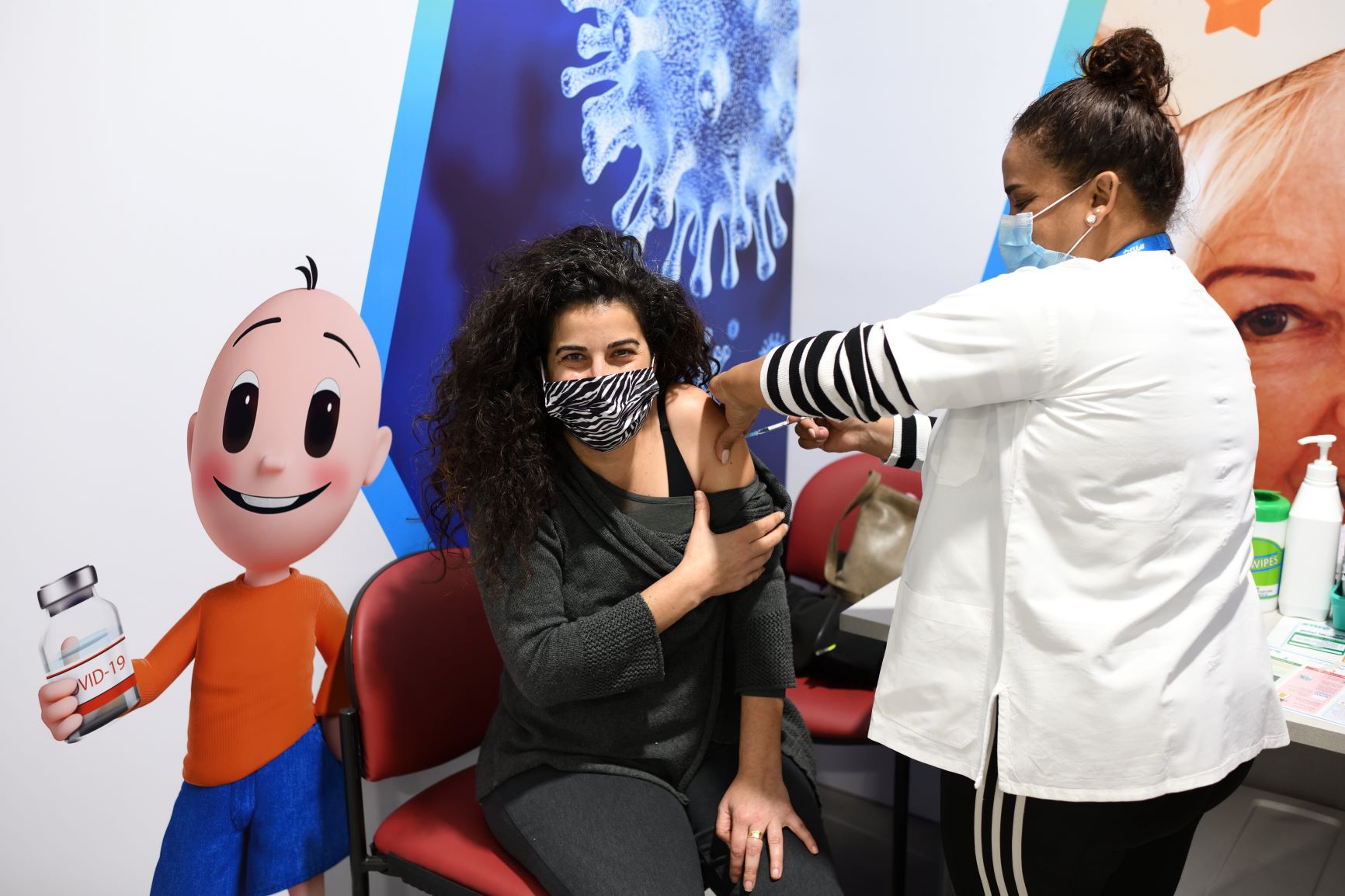 Jovem é vacinada em Herzliya, cidade ao norte de Israel, país com maior número de imunizados: pesquisadora defende que até crianças sejam vacinadas (Foto: Gili Yaari / NurPhoto / AFP)
