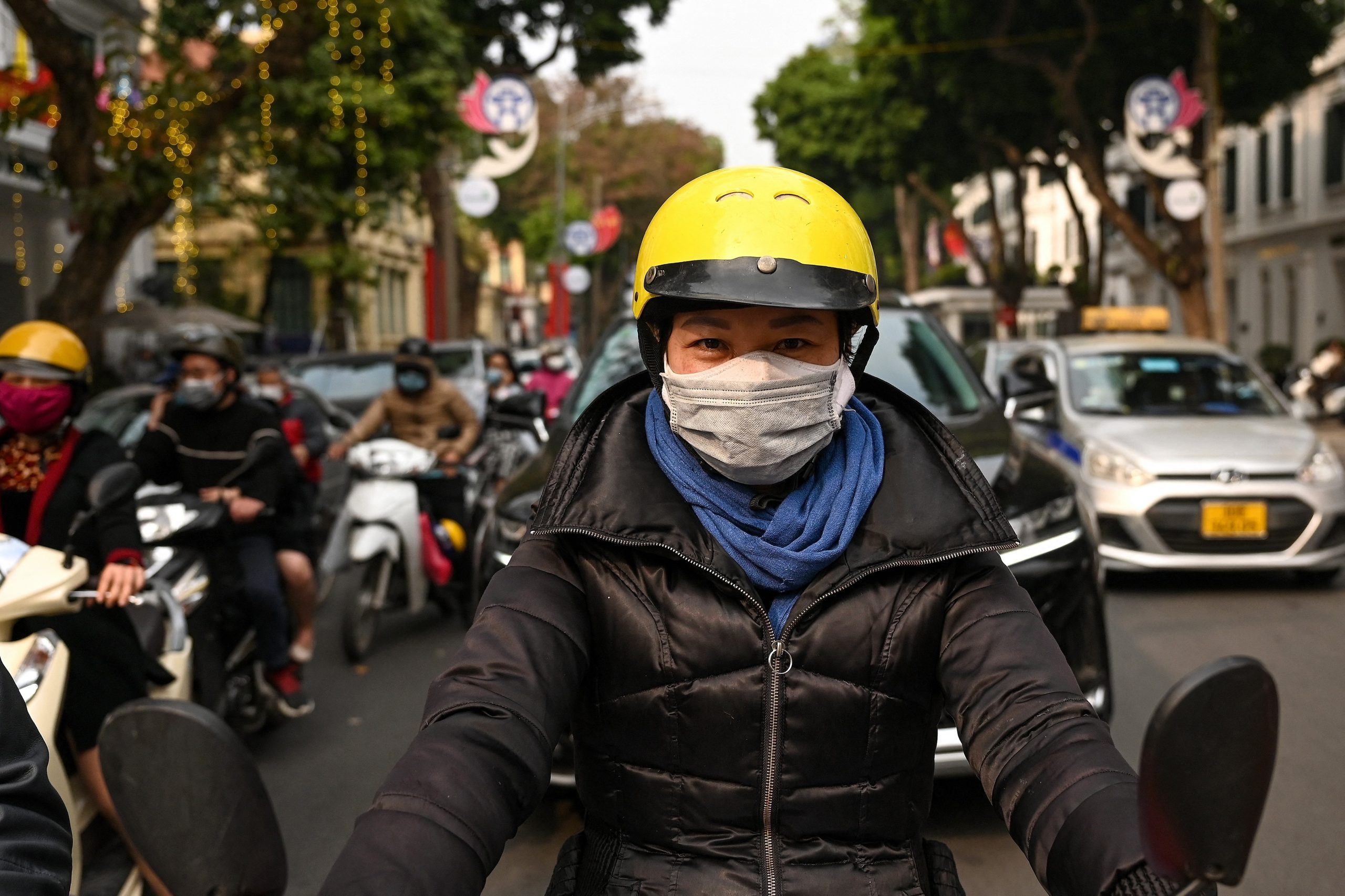 Motociclista com máscara com duas camadas em Hanói, Vietnam: máscaras com duas ou mais camadas de tecido garantem melhor filtragem contra o vírus (Foto: Manan Vatsayana/AFP - 29/01/2021)