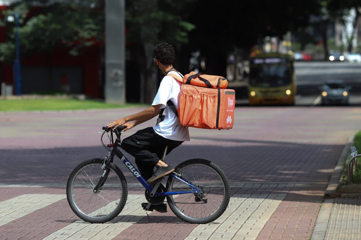 Adolescente faz serviço de entrega em bicicleta em Belo Horizonte: por sobrevivência, jovens se arriscam como entregadores de aplicativos durante a pandemia (Foto: Joana Suarez/Lição de Casa)