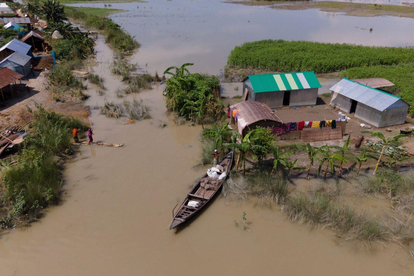 Morador deixa sua casa de barco durante enchente em Bangladesh: Ásia concentrou refugiados climáticos, afetados por desastres relacionados ao clima (Foto: WFP/IMDC)