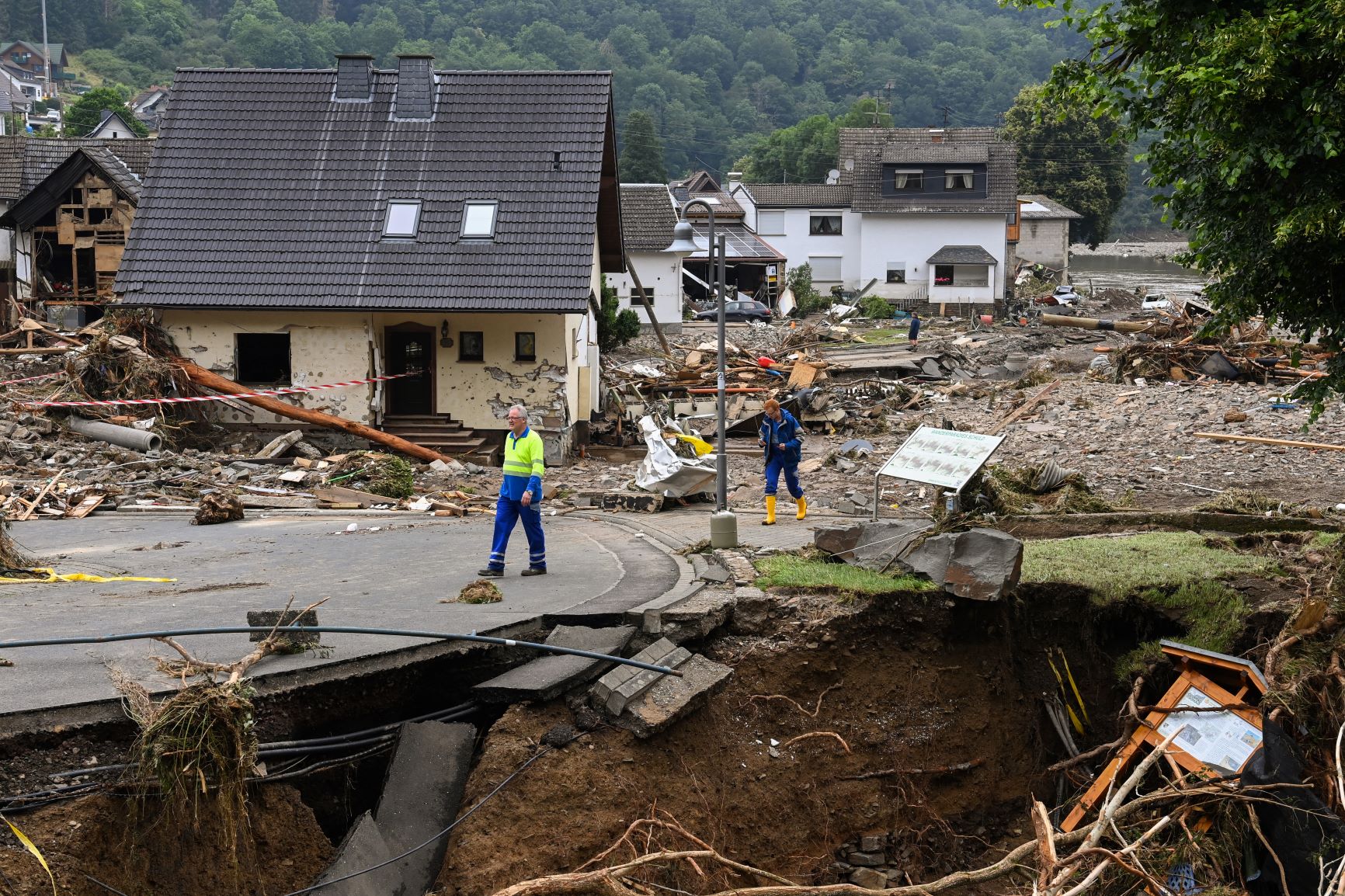 Moradores de Schuld passam por parte da cidade arrasada pelas inundações: alerta disparado pelo serviço meteorológico não chegou a muitas localidades (Foto: Cristof Stache / AFP - 18/07/2021)