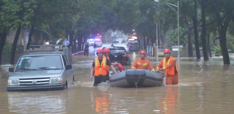 Bombeiros chineses retiram moradores durante enchente em Guangzhou, no sul da China: polo da indústria da moda, terceira cidade do país pode ter muitas fábricas sob as águas até o fim da década, aponta estudo (Foto Cai Zirong / Imaginechina / AFP - 19/04/2019)