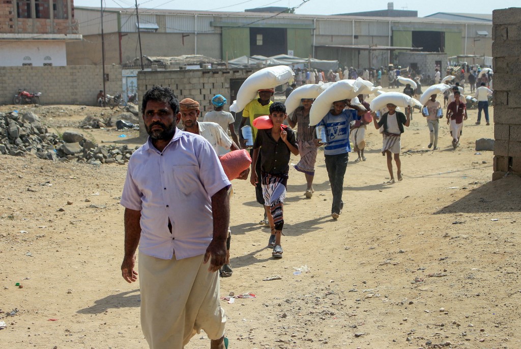 Iemenitas deslocados de suas casas recebem ajuda humanitária do Programa Mundial de Alimentos na província de Haijah: PMA sem recursos e com dificuldades de alcançar todas as regiões do Iêmen por conta da guerra (Foto: Essa Ahmed / AFP - 12/01/2021)