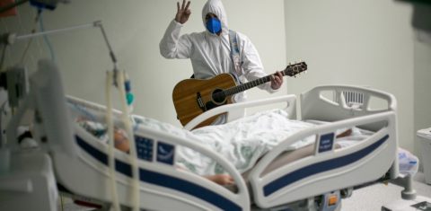 Profissional de saúde canta para um paciente de covid-19 no Hospital Português, em Belém, ,no Pará. Foto Tasso Sarraf/AFP. Abril/2021