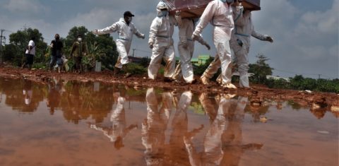 Coveiros carregam o caixão de uma vítima que morreu de covid-19 para ser enterrada em um cemitério em Bekasi, na Indonésia. Foto Rezas/AFP. Agosto/2021
