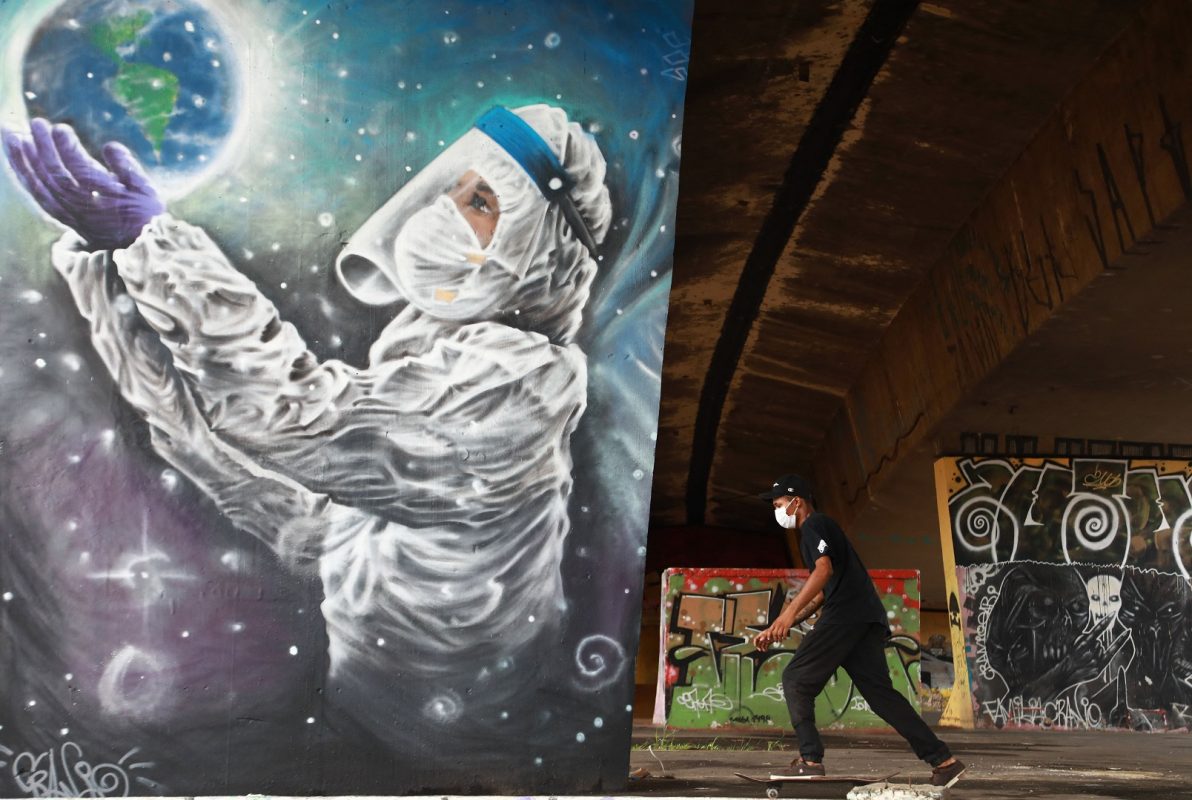 Jovem de skate em frente a um grafite do artista Luciano Cranio, em Sapucaia do Sul, no Rio Grande do Sul: mais de 34 mil mortes de covid-19