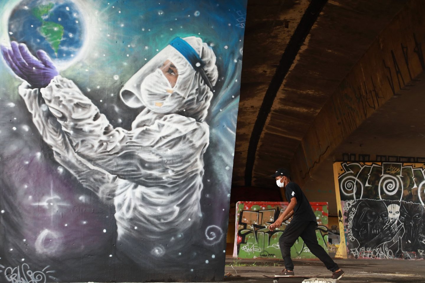 Jovem de skate em frente a um grafite do artista Luciano Cranio, em Sapucaia do Sul, no Rio Grande do Sul: mais de 34 mil mortes de covid-19