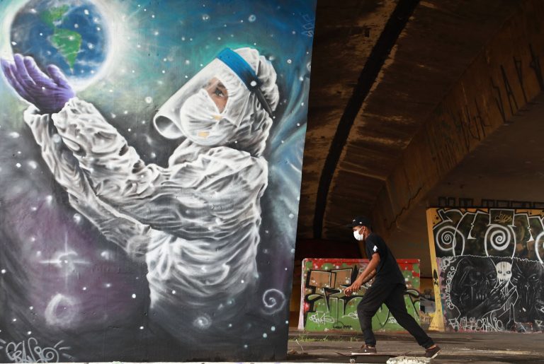Jovem de skate em frente a um grafite do artista Luciano Cranio, em Sapucaia do Sul, no Rio Grande do Sul: mais de 34 mil mortes de covid-19