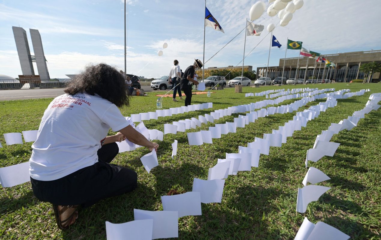 Membros da Associação de Vítimas e Familiares da covid-19 colocam 600 bandeiras brancas em frente ao Congresso Nacional, em Brasília, em homenagem aos 600 mil mortos vítimas da doença. Foto Evaristo Sa/AFP. Outubro/2021