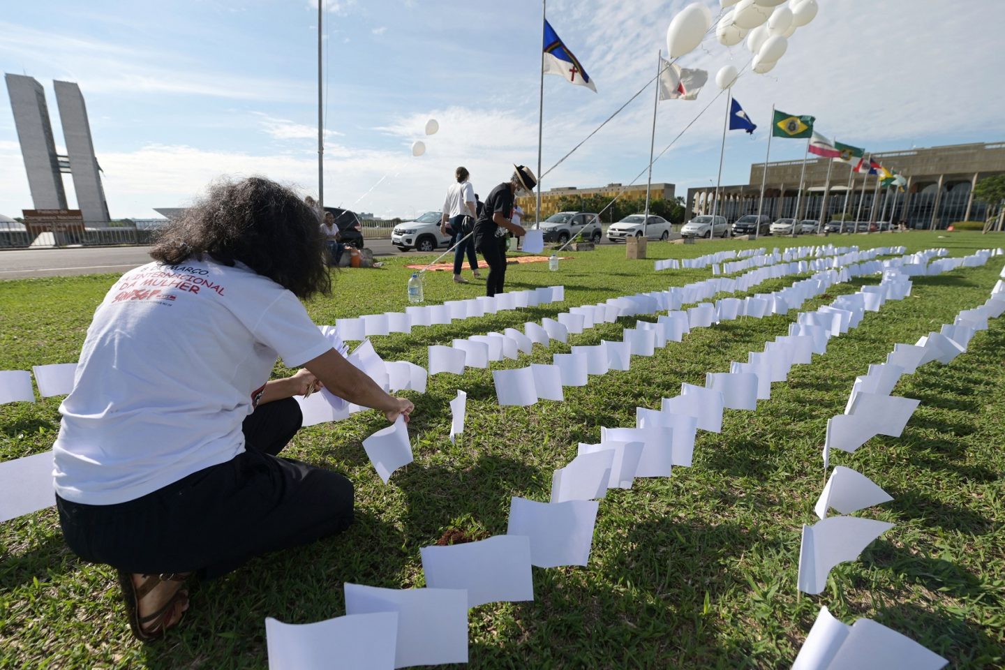 Membros da Associação de Vítimas e Familiares da covid-19 colocam 600 bandeiras brancas em frente ao Congresso Nacional, em Brasília, em homenagem aos 600 mil mortos vítimas da doença. Foto Evaristo Sa/AFP. Outubro/2021