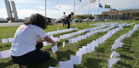 Membros da Associação de Vítimas e Familiares da covid-19 colocam 600 bandeiras brancas em frente ao Congresso Nacional, em Brasília, em homenagem aos 600 mil mortos vítimas da doença. Foto Evaristo Sa/AFP. Outubro/2021