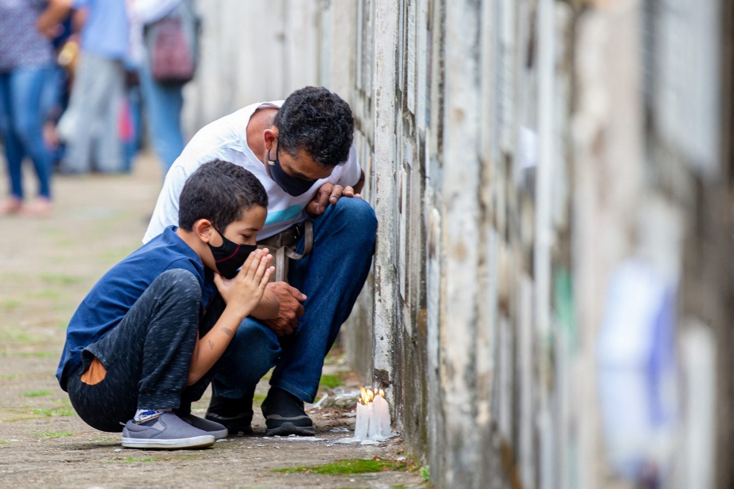 No cemitério Vila Formosa, em São Paulo, Brasil, pai e filho oram pela perda de um parente para a covid-19. Brasil superou a marca de 609 mil mortos para a doença. Foto Paulo Lopes/Anadolu Agency via AFP