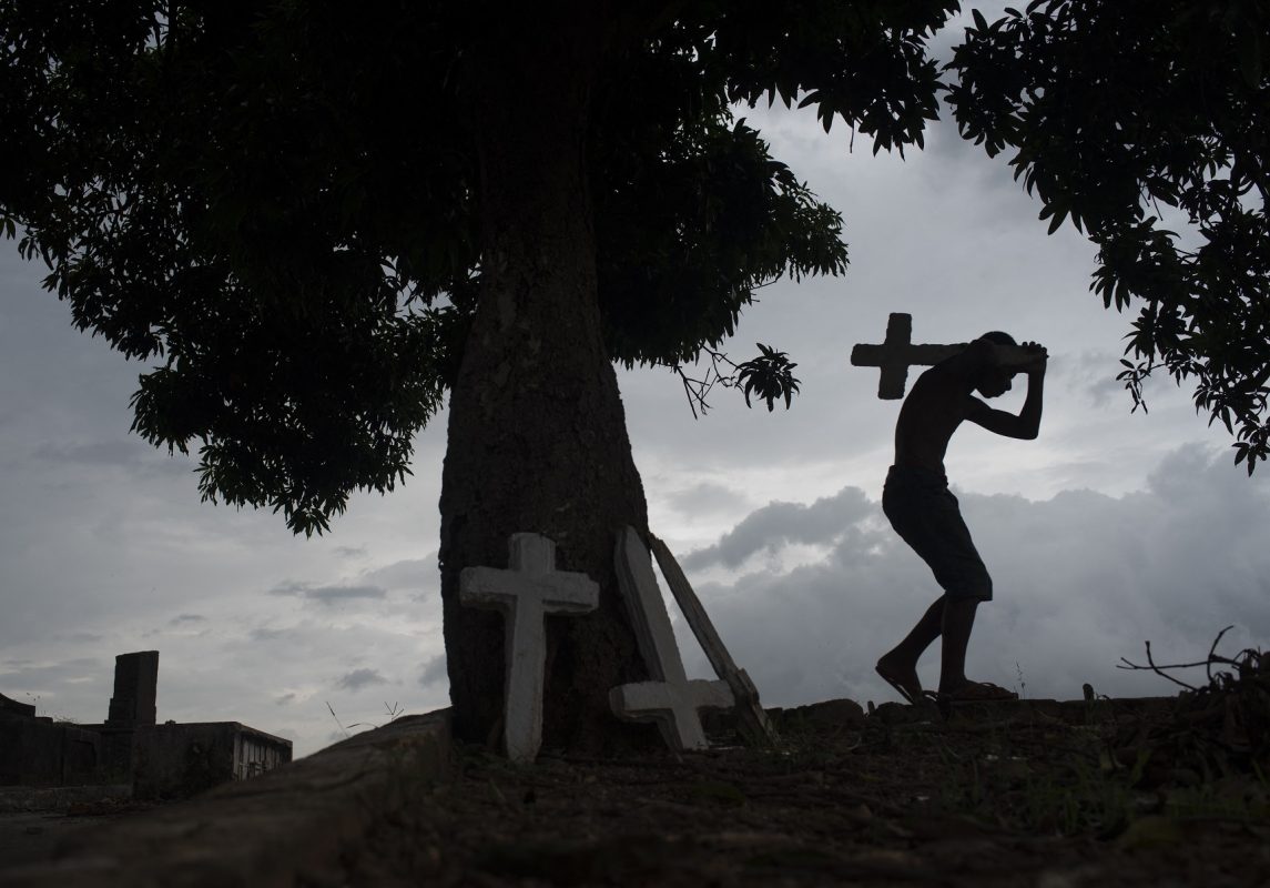Vista de um cemitério no Rio de Janeiro onde crianças trabalham limpando os túmulos: Nunca morreu tanta gente no Brasil. Foto Fabio Teixeira/Anadolu Agency/AFP. Outubro/2021