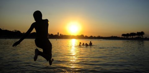 Jovem mergulha no Piscinão de Ramos no fim de tarde do Rio. Cidade deve fechar o ano de 2021 com sete mil habitantes a menos. Foto Fabio Teixeira/Anadolu Agency/Via AFP