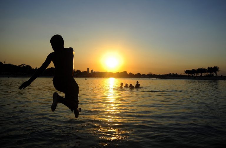Jovem mergulha no Piscinão de Ramos no fim de tarde do Rio. Cidade deve fechar o ano de 2021 com sete mil habitantes a menos. Foto Fabio Teixeira/Anadolu Agency/Via AFP