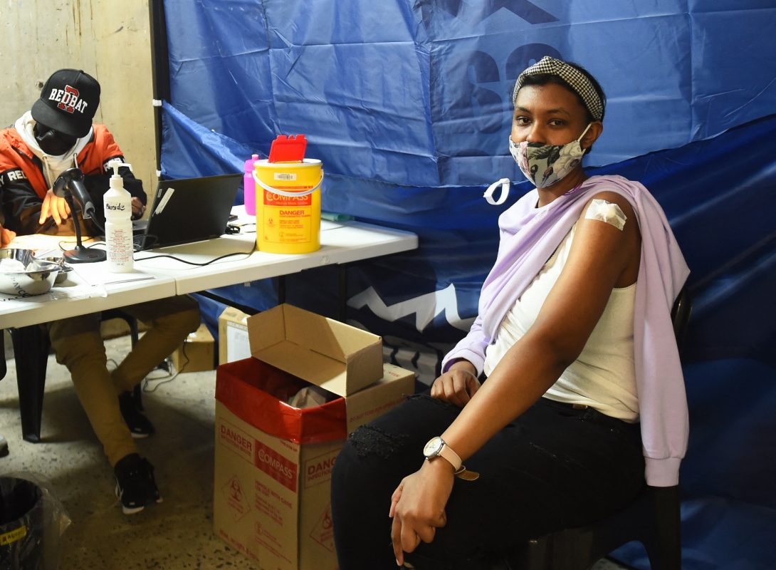 Jovem é atendida em posto de vacinação na Cidade do Cabo. Governo tem enfrentado dificuldades para convencer a população a se vacinar. Foto Xabiso Mkhabela/Anadoly Agency via AFP