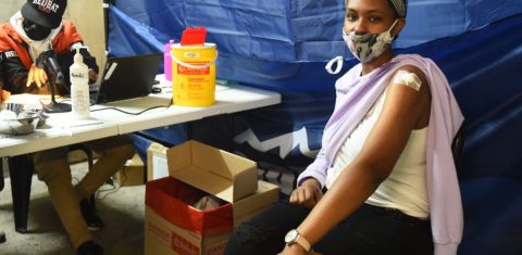 Jovem é atendida em posto de vacinação na Cidade do Cabo. Governo tem enfrentado dificuldades para convencer a população a se vacinar. Foto Xabiso Mkhabela/Anadoly Agency via AFP