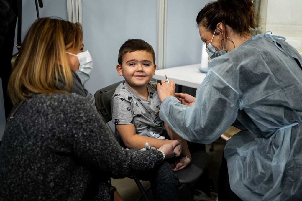 Crianças: em Lyon, na França, o jovem Jordan, de cinco anos, sorri ao receber a primeira dose da vacina contra a covid-19. Foto Hans Lucas/AFP