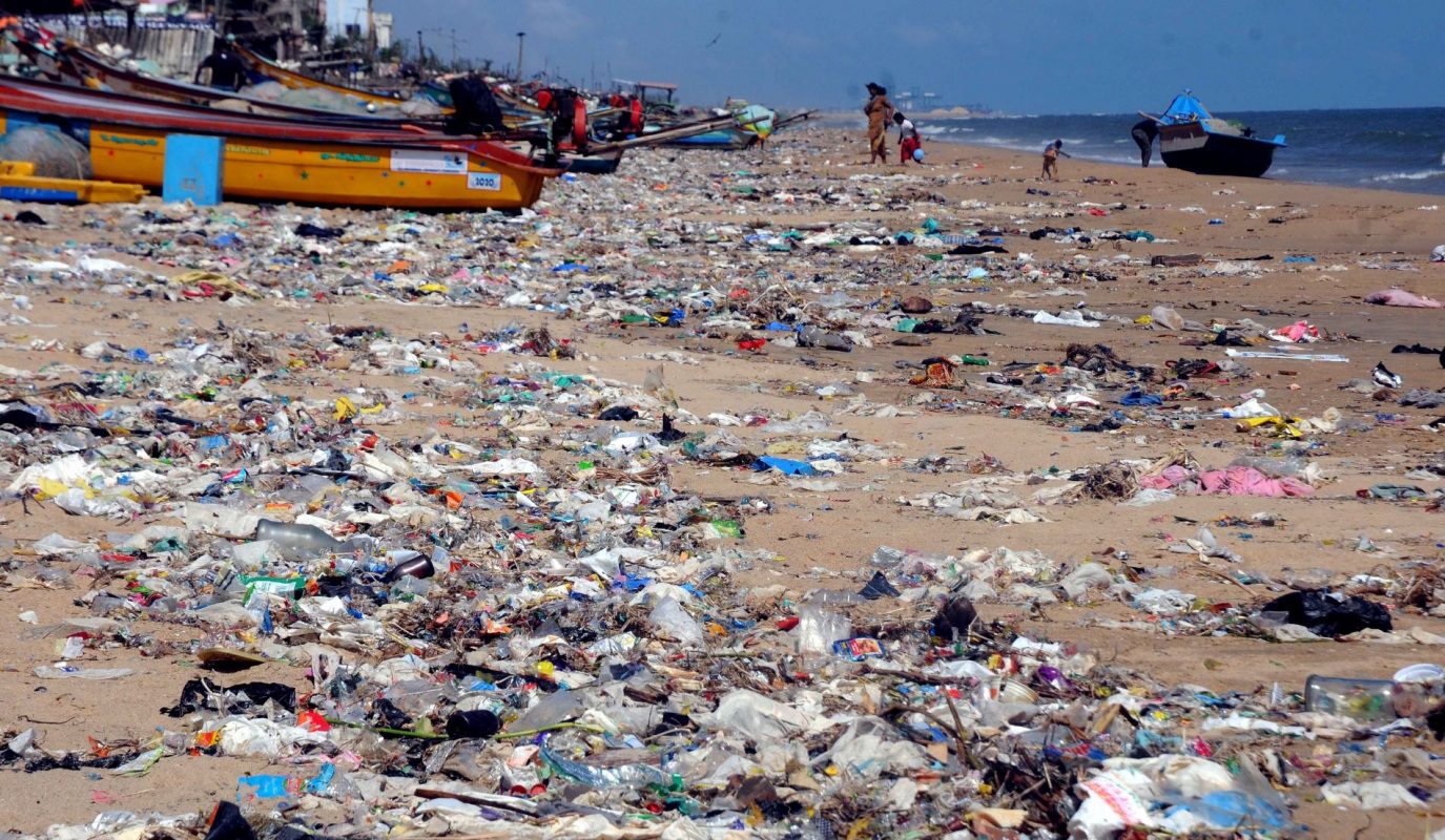 Lixo plástico cobre a areia da praia de Chennai, na Índia: pesquisa descobre micróbios que estão evoluindo para comer e degradar plásticos (Foto: Ramesh Shankar R / The Times of India / AFP - 23/11/2021)