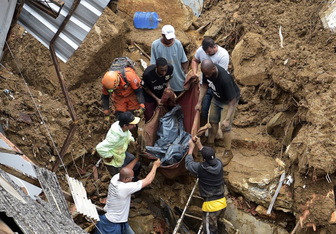 Voluntários retiram corpo de vítima do temporal em Petrópolis: número recorde de mortes marca maior catástrofe climática da Cidade Imperial (Foto: Carl de Souza / AFP)