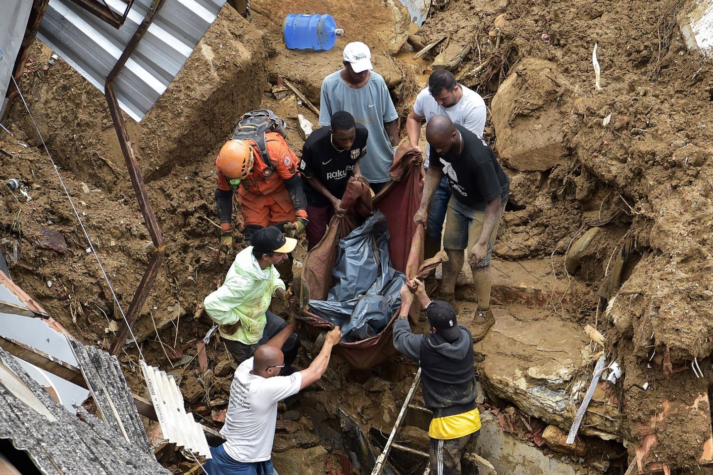 Voluntários retiram corpo de vítima do temporal em Petrópolis: número recorde de mortes marca maior catástrofe climática da Cidade Imperial (Foto: Carl de Souza / AFP)