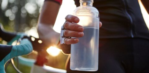 Garrafa reutilizável de plástico na mão de ciclista: pesquisa encontrou 400 substâncias químicas na água (Foto: Maria Fuchs / Cultura Creative / AFP - 31/08/2018)