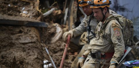 Bombeiros procuram sobreviventes entre os escombros de casas no Morro da Oficina, em Petrópolis. Foto Carl de Souza/AFP