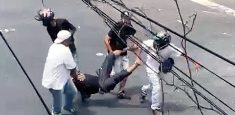 Homens carregam ferido em conflito de torcedores antes do jogo Cruzeiro x Atlético-MG, no domingo (6): um morto. Reprodução
