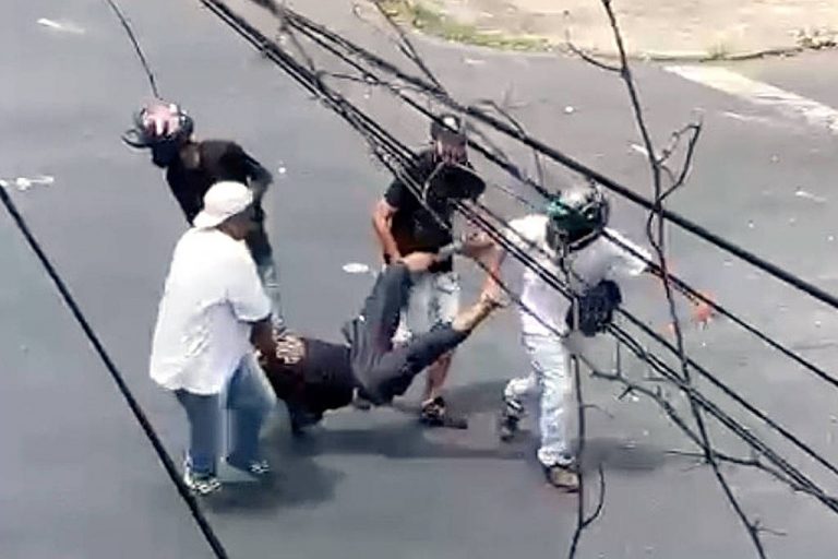 Homens carregam ferido em conflito de torcedores antes do jogo Cruzeiro x Atlético-MG, no domingo (6): um morto. Reprodução