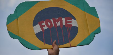 No centro de São Paulo, manifestante segura um cartaz em protesto contra o governo do presidente Jair Bolsonaro. Foto Nelson Almeida/AFP