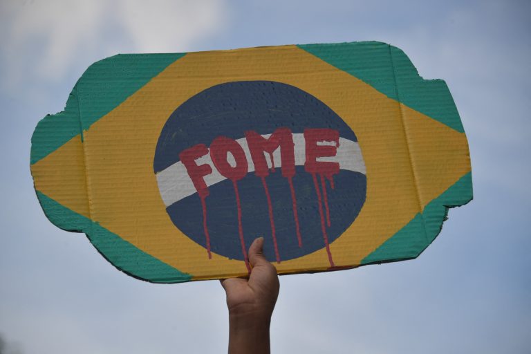 No centro de São Paulo, manifestante segura um cartaz em protesto contra o governo do presidente Jair Bolsonaro. Foto Nelson Almeida/AFP