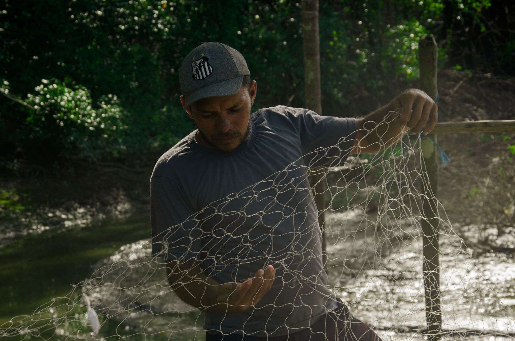 O pescador Élder Júnior e sua rede: grude é o que garante o lucro nas pescarias (Foto: Sarita Reed/Diálogo Chino)