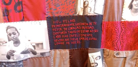 Costura de fotos, cartas, retalhos e bordados em exposição sobre o livro Ausência: correspondência fotográfica para aproximar mulheres presas de seus filhos (Foto: Luiza Sansão)